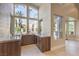 Stylish bar area with wooden cabinetry, marble countertops, and large windows offering outdoor views at 8808 Rozetta Ct, Las Vegas, NV 89134