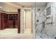Elegant bathroom showcasing a marble shower, glass door, and a glimpse into a spacious walk-in closet at 8808 Rozetta Ct, Las Vegas, NV 89134