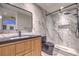 A modern bathroom features a marble walk-in shower, wood cabinet and black fixtures at 8808 Rozetta Ct, Las Vegas, NV 89134