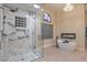 Luxurious bathroom featuring marble walk-in shower, soaking tub with fireplace, and stylish chandelier at 8808 Rozetta Ct, Las Vegas, NV 89134