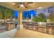 An outdoor kitchen with built-in grill, mini fridge and bar seating at 8808 Rozetta Ct, Las Vegas, NV 89134