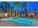 Beautiful in-ground pool and hot tub surrounded by palm trees, lounge chairs, and an outdoor fireplace at 8808 Rozetta Ct, Las Vegas, NV 89134