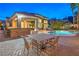 A covered patio featuring a bar and a dining table overlooking a beautiful in-ground pool and hot tub at 8808 Rozetta Ct, Las Vegas, NV 89134