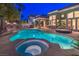 Sparkling in-ground pool and hot tub, an outdoor kitchen, and covered patio with seating at 8808 Rozetta Ct, Las Vegas, NV 89134