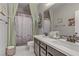 Bathroom with double vanity, decorative mirror, shower with curtain and neutral color palette at 8992 Sparkling River Ct, Las Vegas, NV 89178