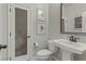 Half bath with pedestal sink, toilet and framed art at 8992 Sparkling River Ct, Las Vegas, NV 89178
