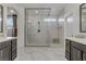 This modern bathroom features dual sink vanities and a glass-enclosed shower at 8992 Sparkling River Ct, Las Vegas, NV 89178