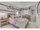 Bedroom showcasing aviation-themed décor, cozy bedding, and natural light through large windows at 8992 Sparkling River Ct, Las Vegas, NV 89178