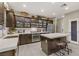 Modern kitchen with dark wood cabinetry, stainless steel appliances, and a center island with seating at 8992 Sparkling River Ct, Las Vegas, NV 89178
