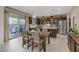 Spacious kitchen with stainless steel appliances, dark cabinetry, and an adjacent dining area at 8992 Sparkling River Ct, Las Vegas, NV 89178
