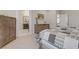 This modern main bedroom features neutral paint and carpet and an ensuite bathroom at 8992 Sparkling River Ct, Las Vegas, NV 89178