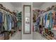 Spacious walk-in closet with full-length mirror and dual hanging racks for optimal clothing storage and organization at 8992 Sparkling River Ct, Las Vegas, NV 89178