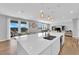 Modern kitchen with a large island, stainless steel sink, and dining and living spaces at 9212 Lunar Effect St, Las Vegas, NV 89143