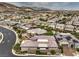 Expansive aerial view of a beige single-story home in a well-planned community with mountain views, offering a peaceful neighborhood setting at 9928 Regency Square Ave, Las Vegas, NV 89148