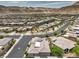 Sprawling aerial showcasing a beige single-story home in an organized community, complete with sidewalks and views of the desert landscape at 9928 Regency Square Ave, Las Vegas, NV 89148