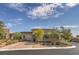 View of the home's exterior, showcasing its desert landscaping, stone accents, and circular tower entrance at 9928 Regency Square Ave, Las Vegas, NV 89148