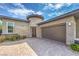 Exterior of the home, highlighting a brick paver driveway, stone accents, tower element, and garage at 9928 Regency Square Ave, Las Vegas, NV 89148
