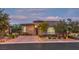 Beautiful home exterior featuring professional landscaping, brick driveway and tasteful outdoor lighting at 9928 Regency Square Ave, Las Vegas, NV 89148