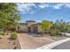 A beautifully landscaped home featuring a circular tower entrance, stone accents, and a brick paver driveway at 9928 Regency Square Ave, Las Vegas, NV 89148