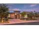 Beautiful home exterior featuring professional landscaping, brick driveway and tasteful outdoor lighting at 9928 Regency Square Ave, Las Vegas, NV 89148