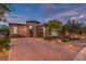 Beautiful home exterior featuring professional landscaping, brick driveway and tasteful outdoor lighting at 9928 Regency Square Ave, Las Vegas, NV 89148