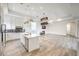 Modern kitchen and living room featuring white cabinets, stainless steel appliances, and a fireplace at 9928 Regency Square Ave, Las Vegas, NV 89148