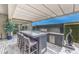 Outdoor kitchen with bar seating, built-in grill, and modern finishes, perfect for outdoor entertaining at 9928 Regency Square Ave, Las Vegas, NV 89148
