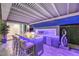 Stylish outdoor kitchen with bar seating, built-in grill, and decorative lighting for evening entertainment at 9928 Regency Square Ave, Las Vegas, NV 89148