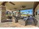 Inviting covered outdoor lounge with comfortable seating, ceiling fans, stone columns, and a built-in grill for relaxing or entertaining at 9928 Regency Square Ave, Las Vegas, NV 89148