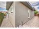 Side yard of the home featuring neutral stucco, gravel landscaping, and narrow walking path at 9928 Regency Square Ave, Las Vegas, NV 89148