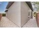 Side yard of the home showing stucco, gravel landscaping, and a narrow walking path at 9928 Regency Square Ave, Las Vegas, NV 89148