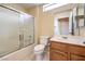Bright bathroom featuring a shower-tub combination with a frosted glass sliding door and wood vanity at 9948 Bundella Dr, Las Vegas, NV 89134