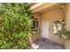 Cozy front porch area with a white door, lush greenery, and a decorative outdoor lantern at 9948 Bundella Dr, Las Vegas, NV 89134