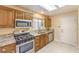 Well-lit kitchen featuring stainless steel appliances, granite countertops, and wooden cabinets at 9948 Bundella Dr, Las Vegas, NV 89134