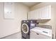 Laundry room featuring a navy washer and white dryer, with white storage cabinets above at 9948 Bundella Dr, Las Vegas, NV 89134