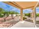 Covered patio overlooking a meticulously landscaped backyard with mature trees and pebble ground cover at 9948 Bundella Dr, Las Vegas, NV 89134