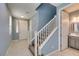 Bright entryway featuring neutral tile, a carpeted staircase, blue accent walls, and access to a half bathroom at 1417 Brushback Ave, Henderson, NV 89074