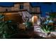 Charming front entrance with a stone-accented facade, an arched doorway, and lush landscaping under evening lights at 1417 Brushback Ave, Henderson, NV 89074