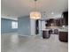 Open kitchen and living space with dark wood cabinetry, island, and stainless steel appliances at 1417 Brushback Ave, Henderson, NV 89074