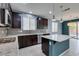 Well-lit kitchen with a granite island, stainless steel appliances, and tiled backsplash at 1417 Brushback Ave, Henderson, NV 89074