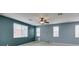 Bright living room featuring tile flooring, a ceiling fan, and multiple windows at 1417 Brushback Ave, Henderson, NV 89074