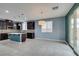 Spacious living area featuring a kitchen island and access to the backyard through sliding glass doors at 1417 Brushback Ave, Henderson, NV 89074