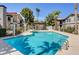 Community pool and apartment buildings with landscaping and palm trees, with blue sky and fair weather at 1575 W Warm Springs Rd # 413, Henderson, NV 89014