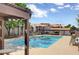 View of the community pool with chairs and tables, apartment buildings and carports in the background at 1575 W Warm Springs Rd # 413, Henderson, NV 89014