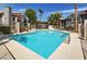 Community pool and apartment buildings with landscaping and palm trees, with blue sky and fair weather at 1575 W Warm Springs Rd # 413, Henderson, NV 89014
