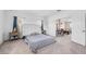 Neutral-toned main bedroom showcasing a large upholstered headboard, soft carpet, and view to the hallway at 1604 Danielle Rebecca Ave, North Las Vegas, NV 89086