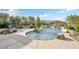 Serene backyard pool area with a custom design and natural rock accents surrounded by landscaping at 1604 Danielle Rebecca Ave, North Las Vegas, NV 89086