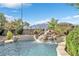 Backyard pool with a stunning rock waterfall feature and vibrant desert landscaping at 1604 Danielle Rebecca Ave, North Las Vegas, NV 89086