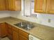 Close-up of a kitchen sink and countertops, showcasing wood cabinets and natural light at 1675 Jupiter Ct # C, Las Vegas, NV 89119