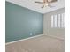 Well-lit bedroom with neutral carpet, blue accent wall, and plantation shutters at 234 Polaris Ridge Ave, Henderson, NV 89011